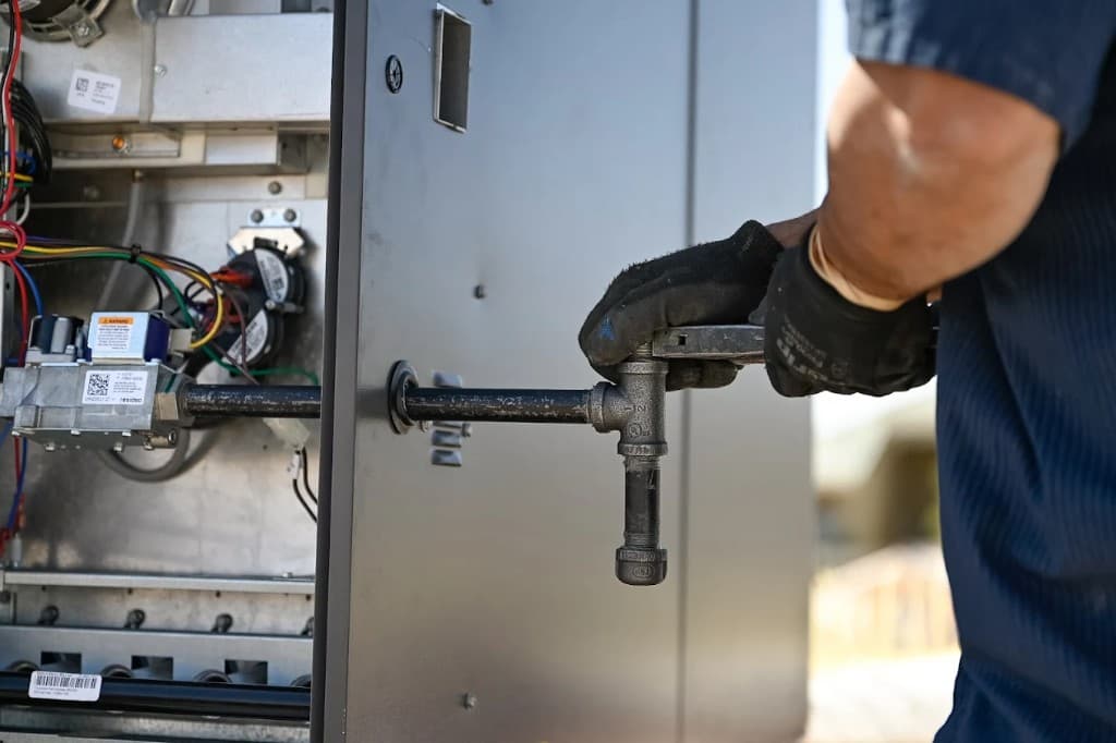 Plumber in Green Valley, Henderson | Active Plumbing. Technician working on gas line connections for residential heating equipment.