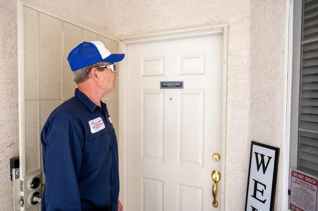 Emergency Plumbing in Las Vegas Valley | Active Plumbing. Uniformed Active Plumbing technician at a residential front door for a scheduled appointment.